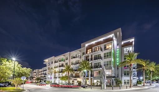 A modern building with the name "Residence" on it is lit up at night.