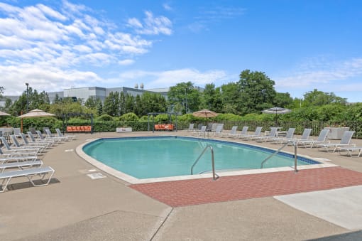 a swimming pool with chaise lounge chairs and umbrellas