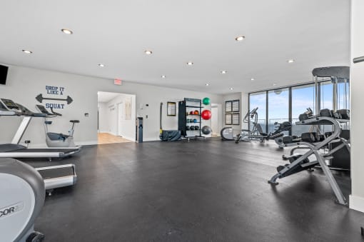a workout room with cardio equipment and a view of the ocean