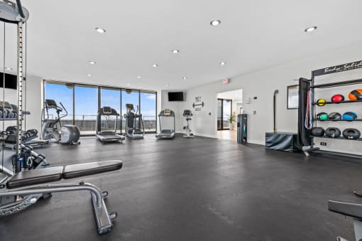 a large fitness room with cardio equipment and a view of the ocean