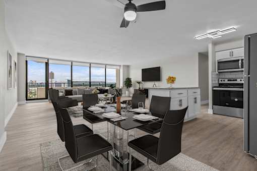 A modern dining room with a glass table and black chairs.