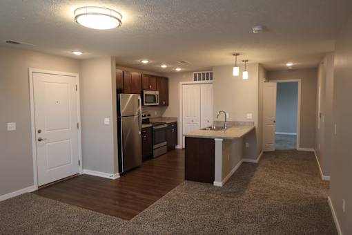 A kitchen with a refrigerator, microwave, and sink.