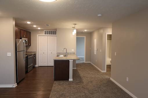 A kitchen with a refrigerator, sink, and cabinets.