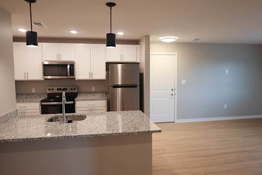 A kitchen with a granite countertop and stainless steel appliances.