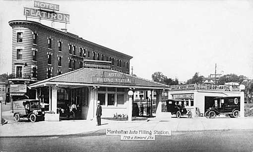 A black and white photo of the Flatiron Hotel and a car dealership.