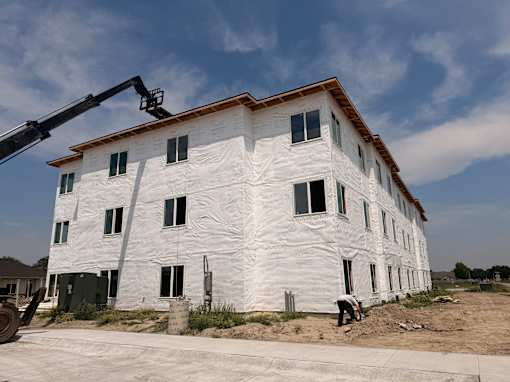 A building under construction with a crane on the left side.