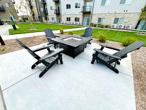 a patio with a fire pit and chairs