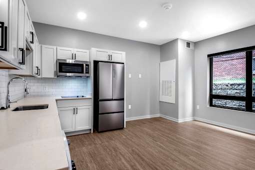 a kitchen with white cabinets and stainless steel refrigerator