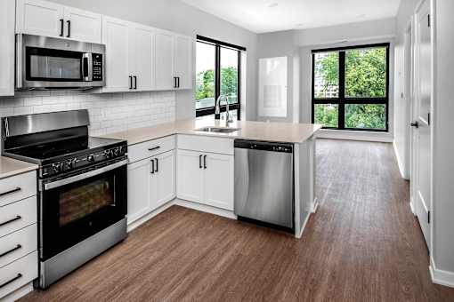 a white kitchen with stainless steel appliances and white cabinets