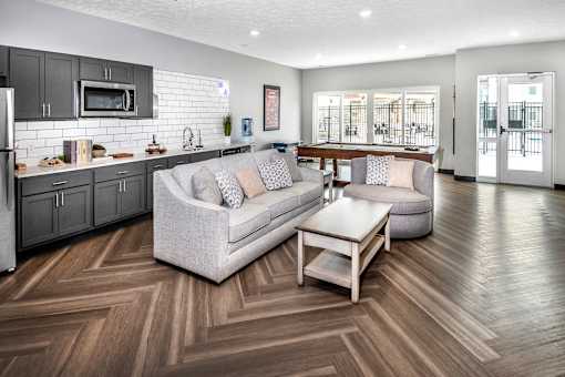 A modern living room with a grey couch and a wooden floor.