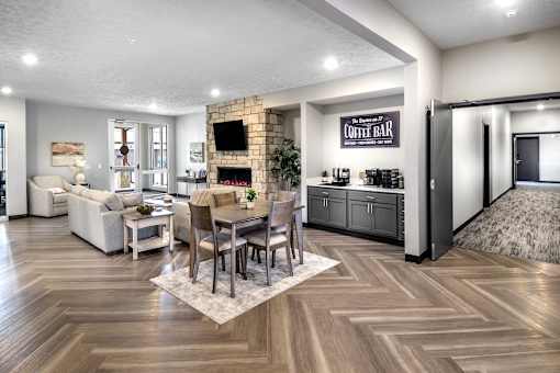 A modern living room with a coffee bar and a fireplace.
