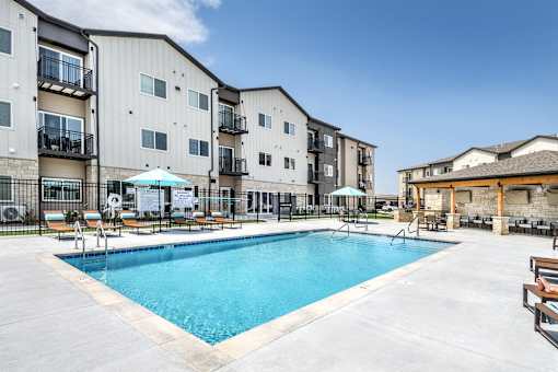 A swimming pool in front of apartment buildings.