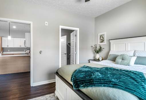 A bedroom with a bed, a dresser, and a mirror.
