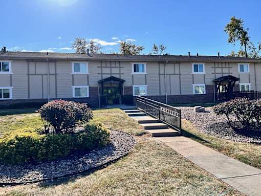 Exterior of an apartment building at Cambridge Apartments, with a sidewalk in front of the building.