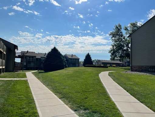 Residential buildings at Fox Run Apartments surrounded by open green space under a clear sky.