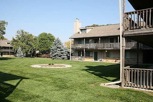 The Eden West Apartments complex, featuring lush green grass and trees surrounding the area.