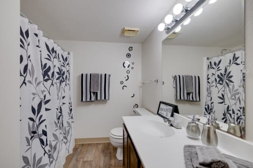 Bathroom in the two-bedroom model unit at Olde English Village, featuring a clean layout with a bathtub and ample storage.
