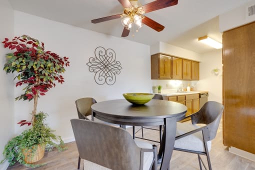Dining area in the two-bedroom model unit at Olde English Village, with the kitchen visible in the background.