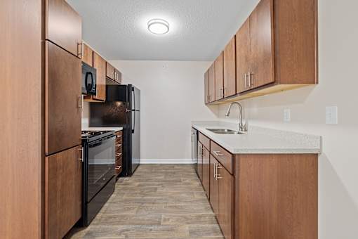 Kitchen with wooden cabinets and neutral flooring at Olde English Village