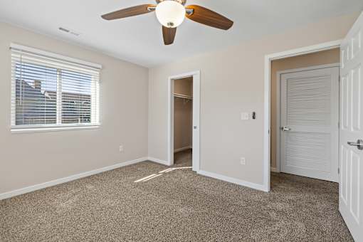 Bedroom with ceiling fan and carpeted floor at Olde English Village