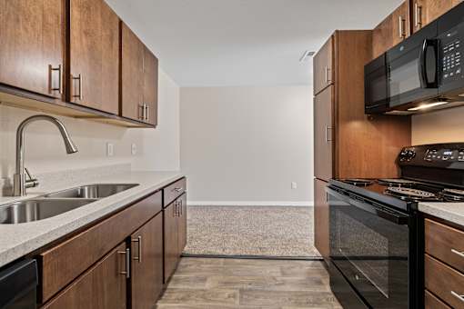 A kitchen with wooden cabinets and a black stove top oven.