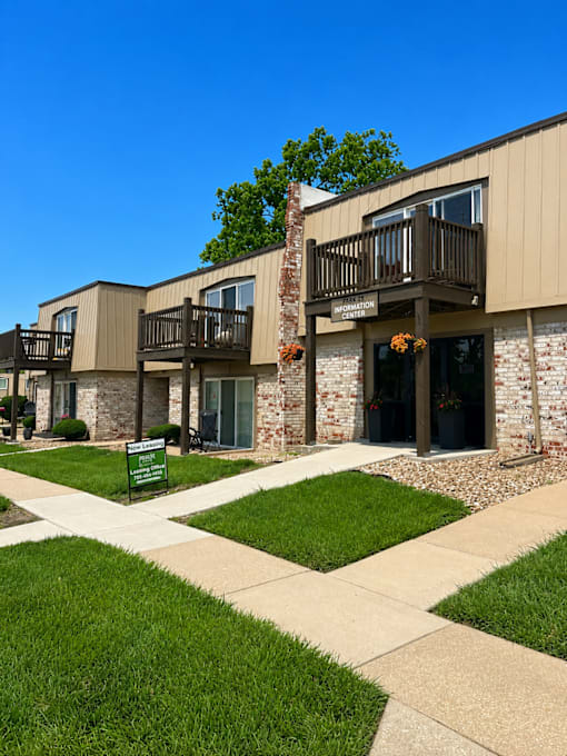 Park 25 Apartments leasing office entrance featuring community signage, landscaped grass, and building exterior.