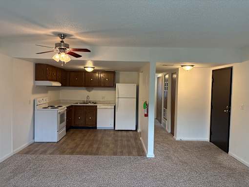 Vacant apartment kitchen at Park 25 Apartments featuring cabinets, refrigerator, and stove.