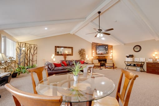 Regency Woods Community Clubhouse Regency Woods Clubhouse living room with a glass table and chairs.