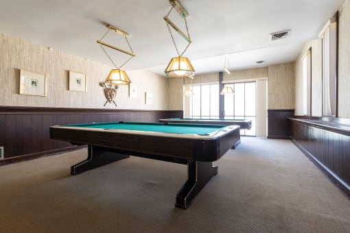 A spacious game room at Regent’s Walk Apartment Homes, featuring a billiards table and seating area.