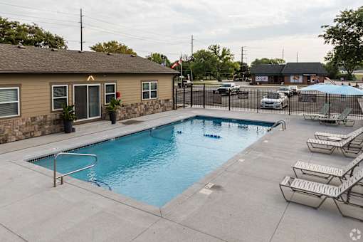 Southfork pool with sun loungers, umbrellas, and lounge chairs.