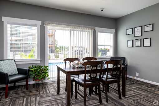A dining room with a table and chairs.