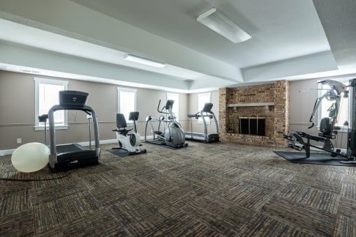 The resident fitness center at Tanglewood Apartments features a variety of exercise equipment, including treadmills, ellipticals, exercise bikes, and weightlifting equipment, in a clean and inviting space.