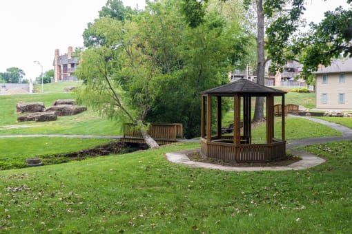 A picturesque gazebo stands in the center of a lush green park within the Tanglewood Apartment Complex.