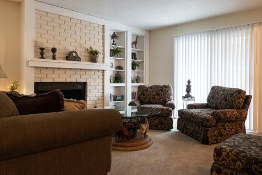 A cozy Tanglewood Model Unit-Living Room features comfortable couches and chairs around a welcoming fireplace.