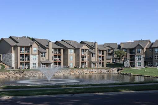 Three Lakes apartment buildings with a water fountain in front, creating a welcoming community setting.