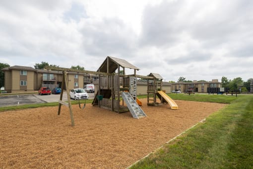 Colorful playground with various play equipment like slides and swings, offering a fun space for children.