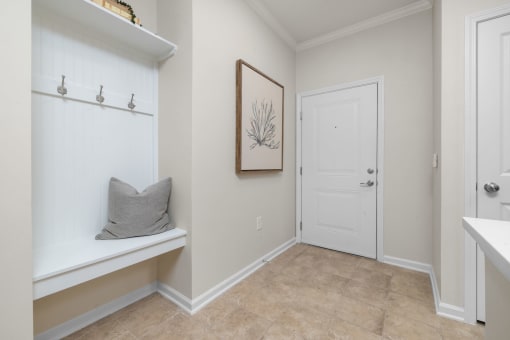 a bathroom with a white door and a shelf with a pillow