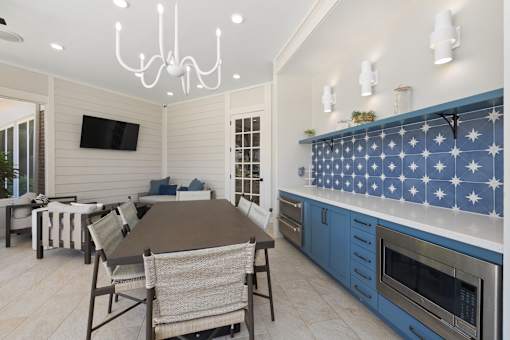 A kitchen with a table and chairs and a television.