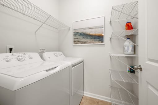 a white washer and dryer in a laundry room with a white closet