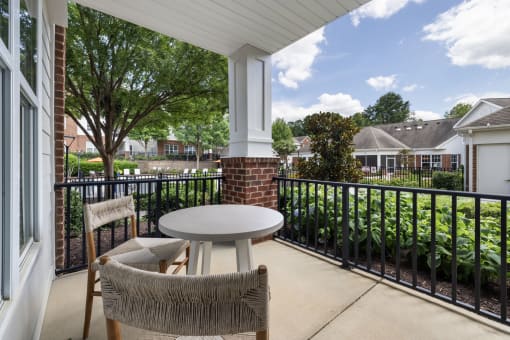 a patio with two chairs and a table on a balcony