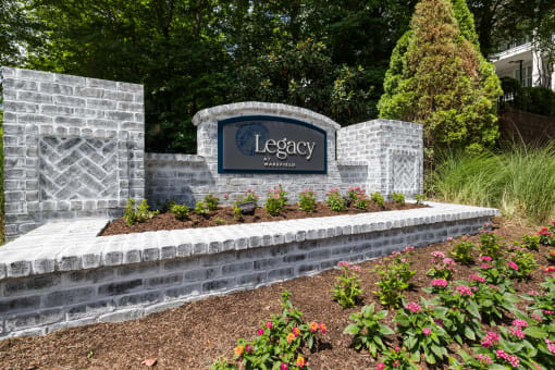 a sign for legacy at the entrance of a garden