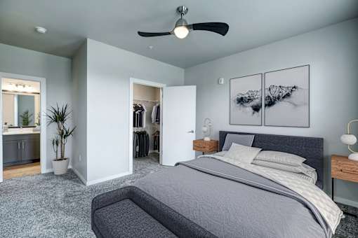 A bedroom with a large bed and a ceiling fan.