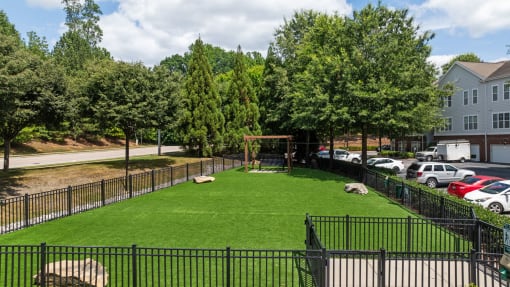 the yard is fenced off with a grass lawn and a swing set