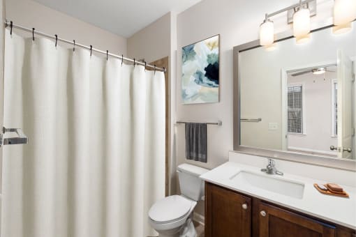 a bathroom with a white shower curtain and a sink and a toilet