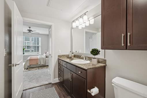 A bathroom with a brown vanity and a white bathtub.