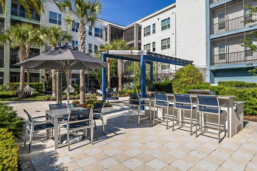 a patio with tables and chairs and umbrellas at an apartment building