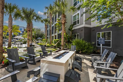 a patio with chairs and a fire pit