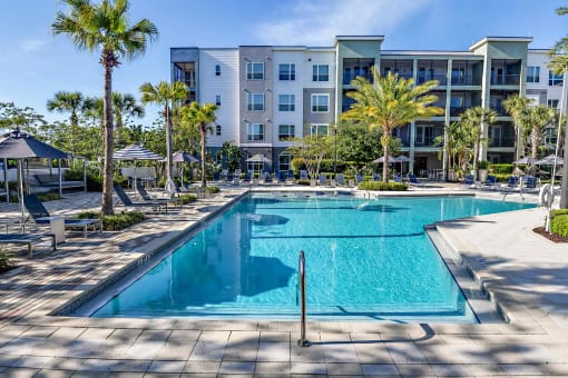 a swimming pool with an apartment building in the background