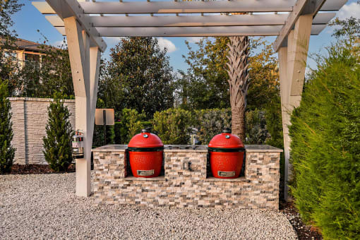 two red trash cans sitting on a brick wall under a roof