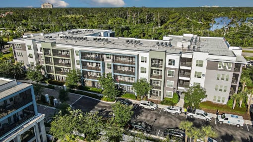 an aerial view of a large apartment building with cars parked outside